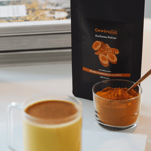 Ölich Kurkuma Pulver 200 g im Beutel neben einem Glas Kurkuma Latte